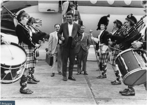 1965 - MUHAMMAD ALI IN POSSIL In 1965, Ali, then still known as Cassius Clay, jetted in to Glasgow to fight Jimmy Ellis at the Paisley ice rink in an exhibition fight. A pipe band greeted him on arriv